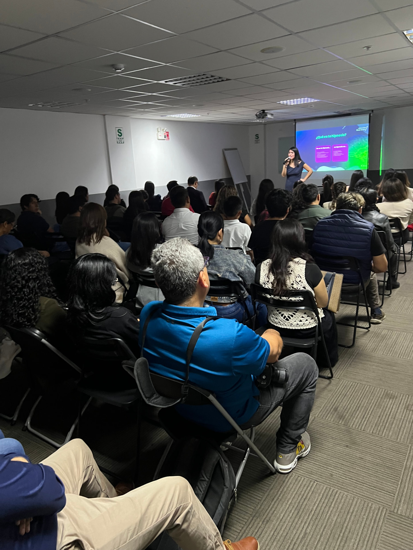 Sala llena durante una charla presencial de Johana Guevara